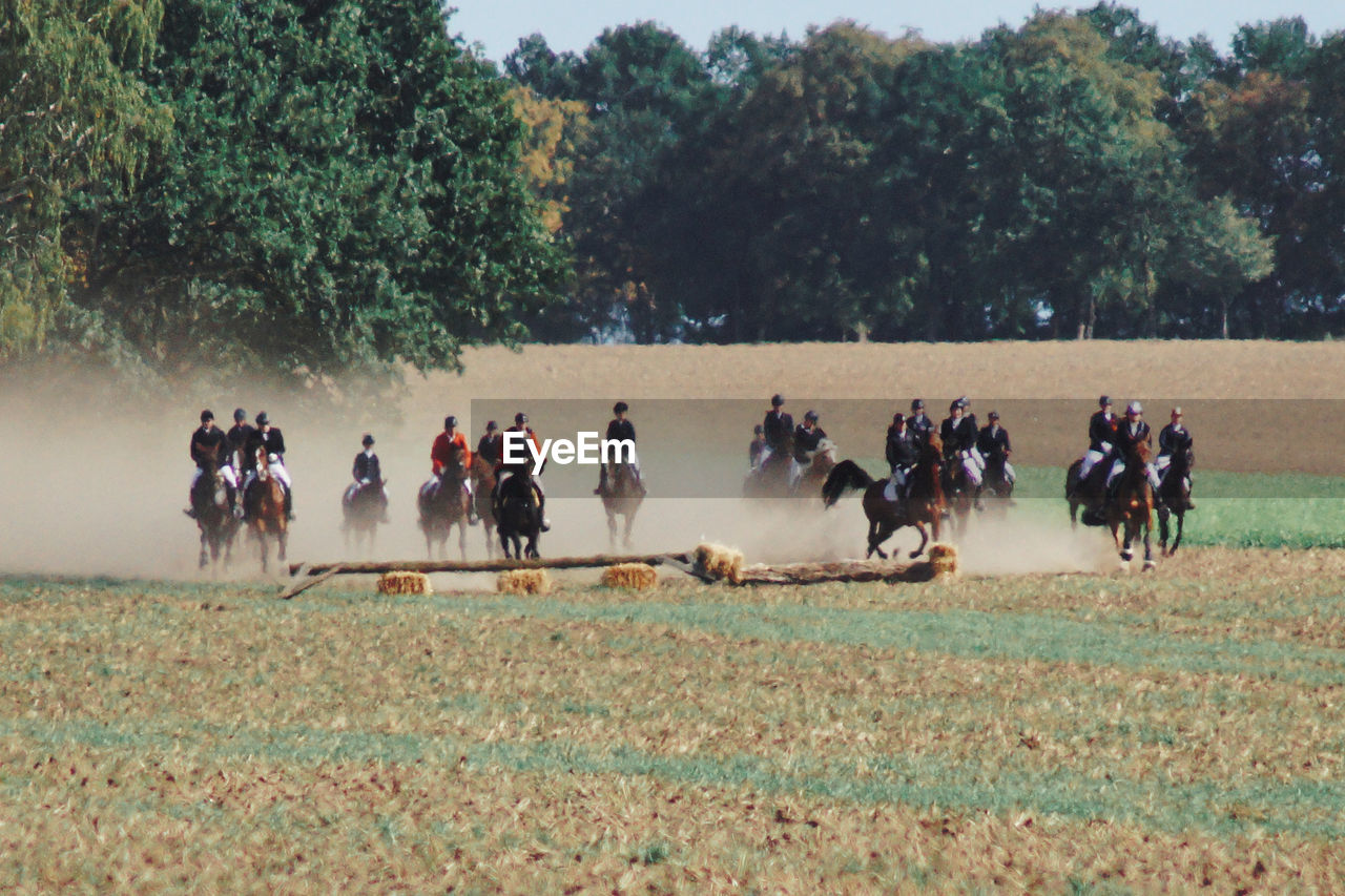 Group of people riding horses on a field at traditional fuchsjagd 