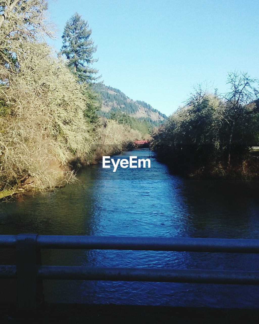 Scenic view of river by mountain against sky