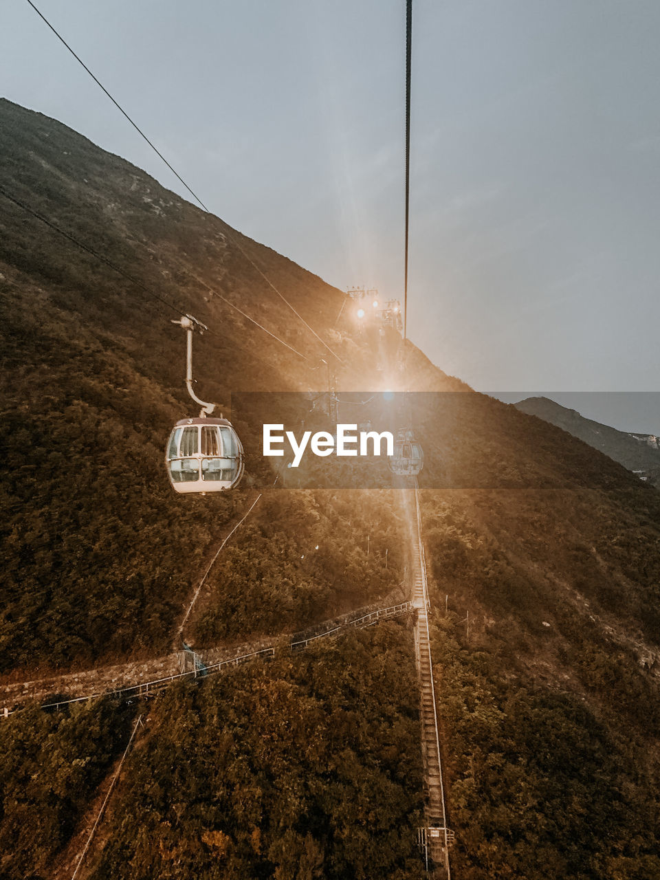 Overhead cable car on mountain road against sky