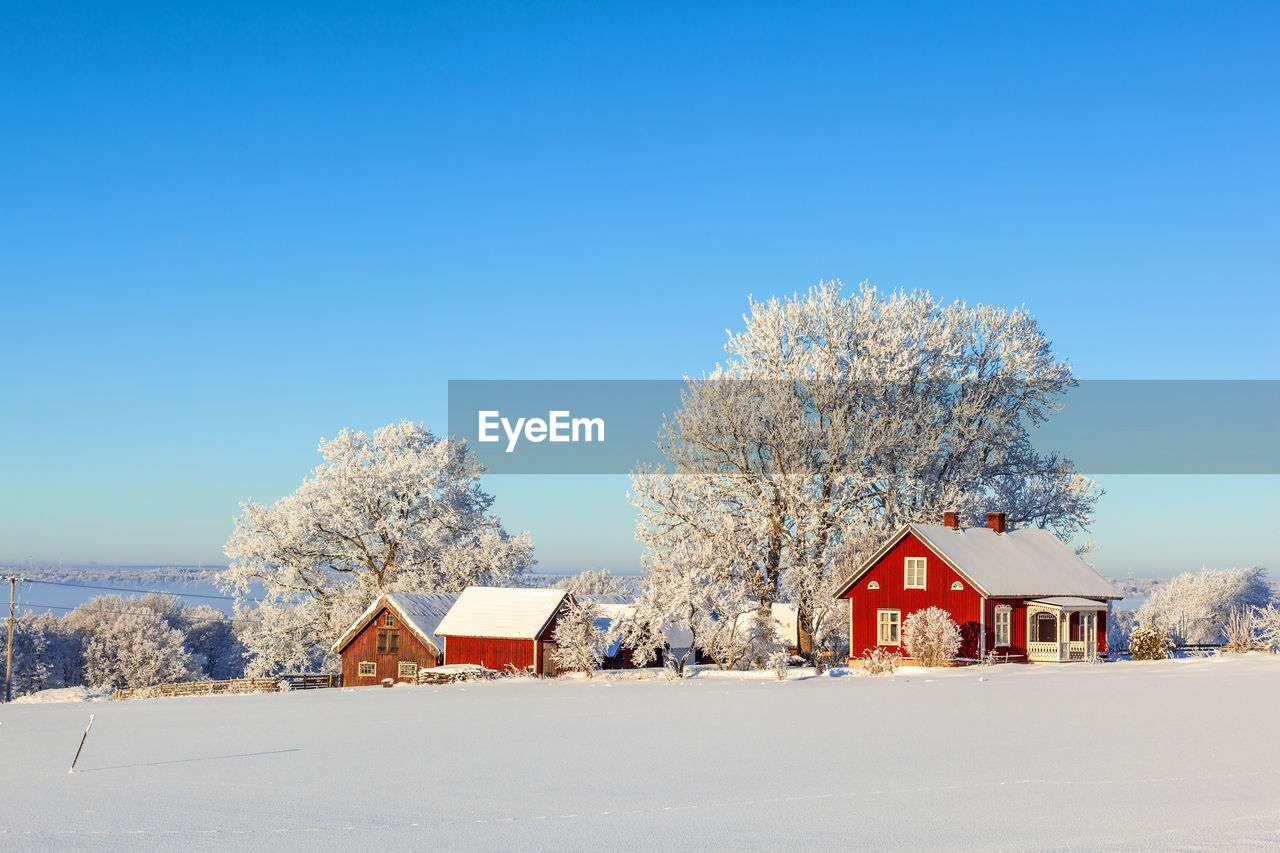 Farm by a snowy field on a beautiful winter day