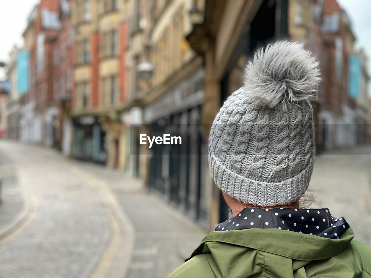 REAR VIEW OF WOMAN WITH UMBRELLA IN WINTER