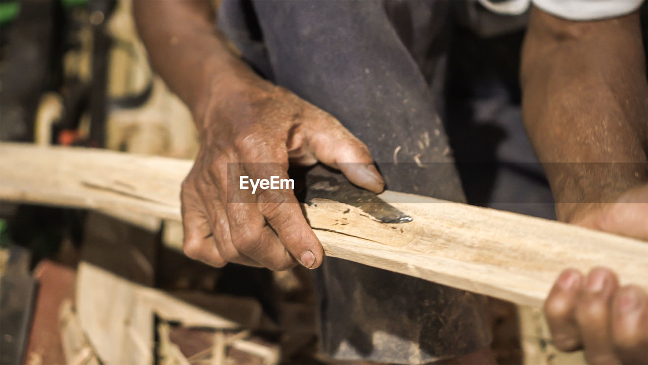 MIDSECTION OF MAN WORKING WITH WOOD