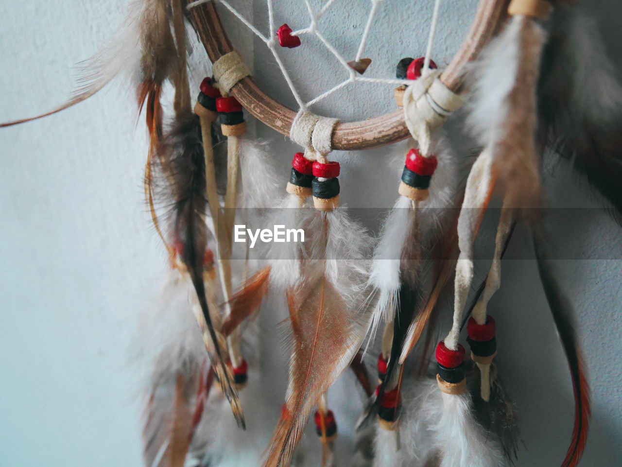 Close-up of dreamcatcher hanging by wall