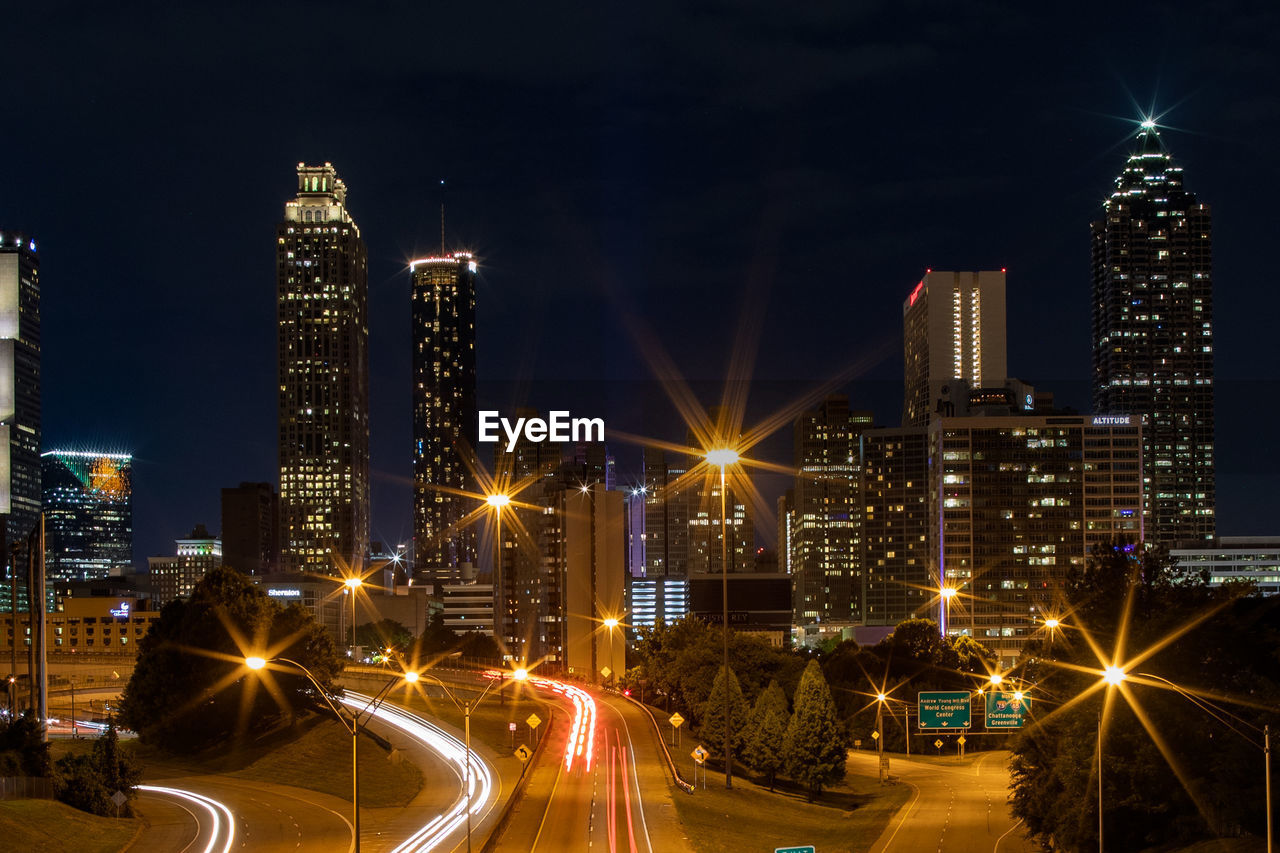 Illuminated buildings against sky at night