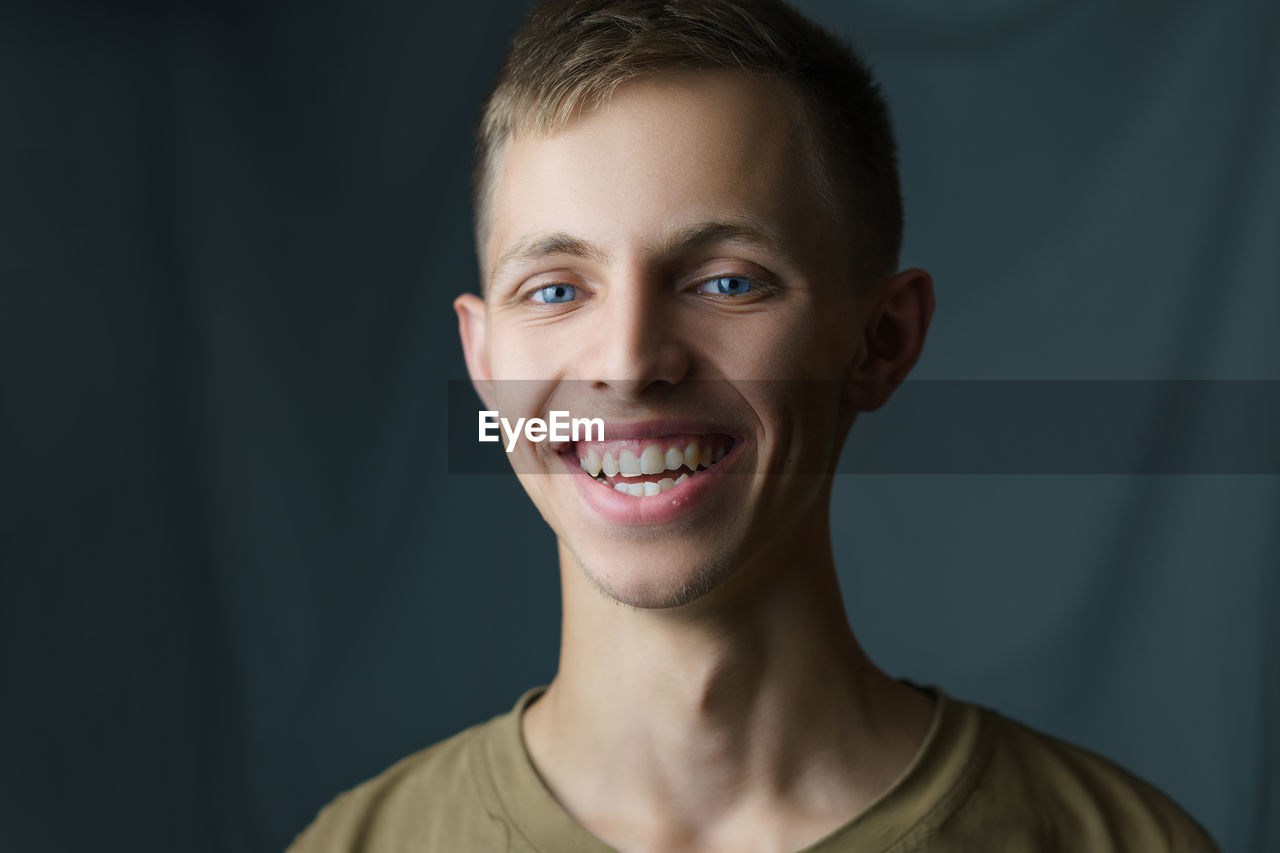 PORTRAIT OF SMILING YOUNG MAN