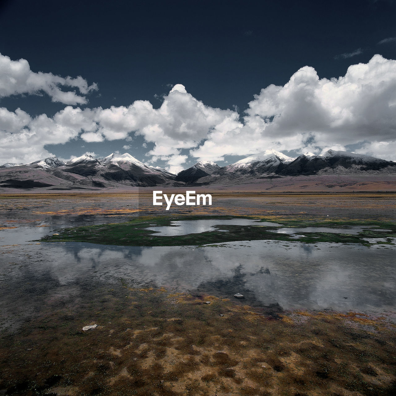 Scenic view of lake by mountains against sky