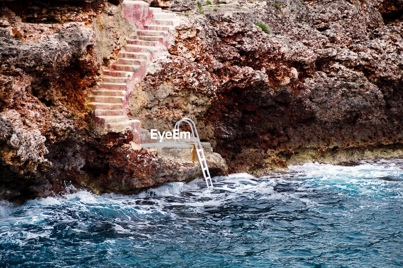 High angle view of water flowing through rocks at staircase