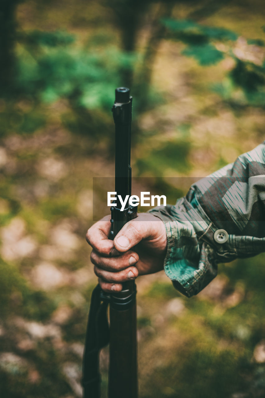 Cropped hand of army holding rifle