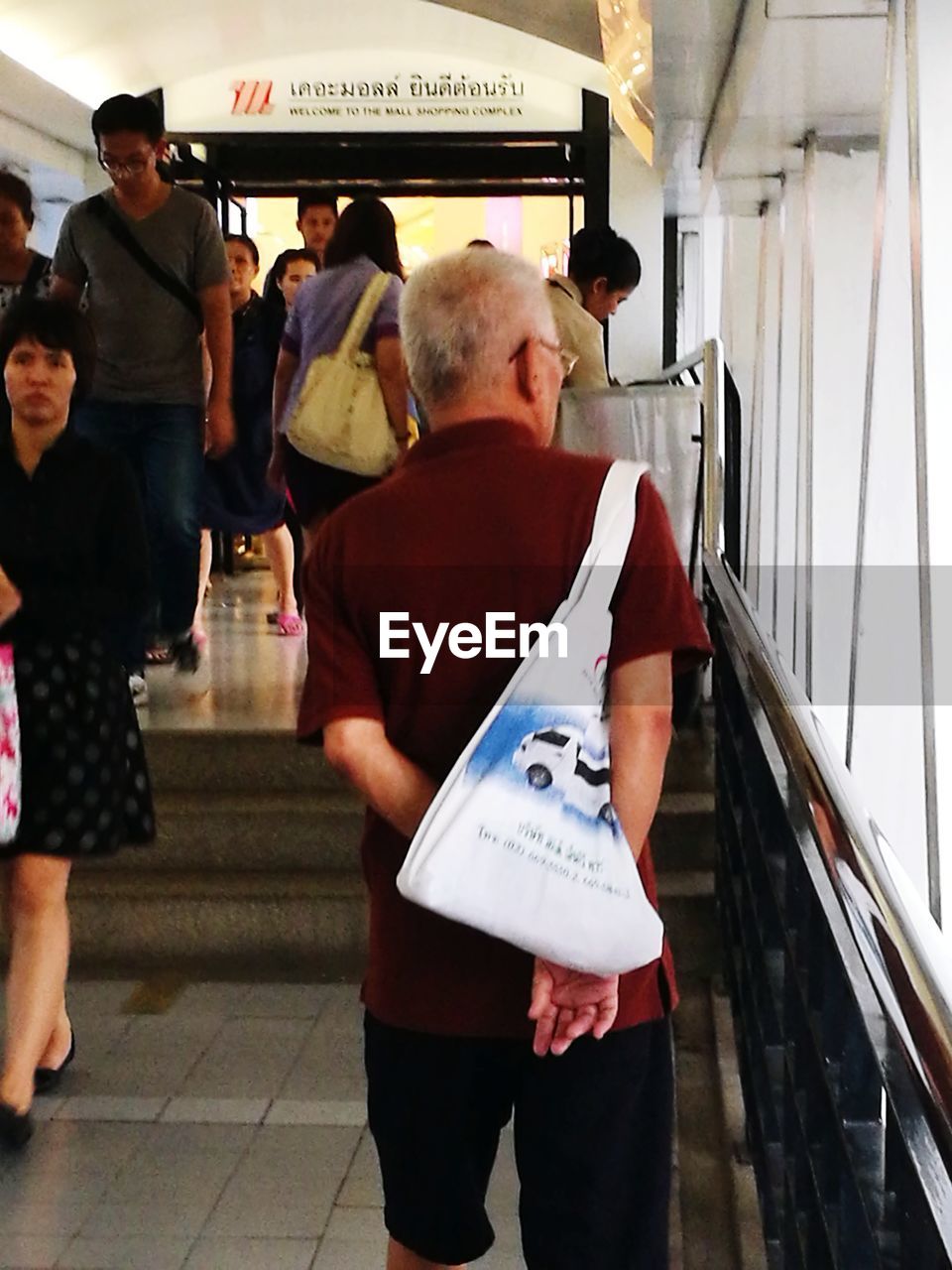 REAR VIEW OF PEOPLE STANDING IN SUBWAY