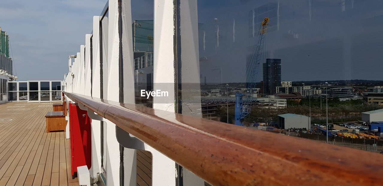 Buildings reflecting on glass of ship