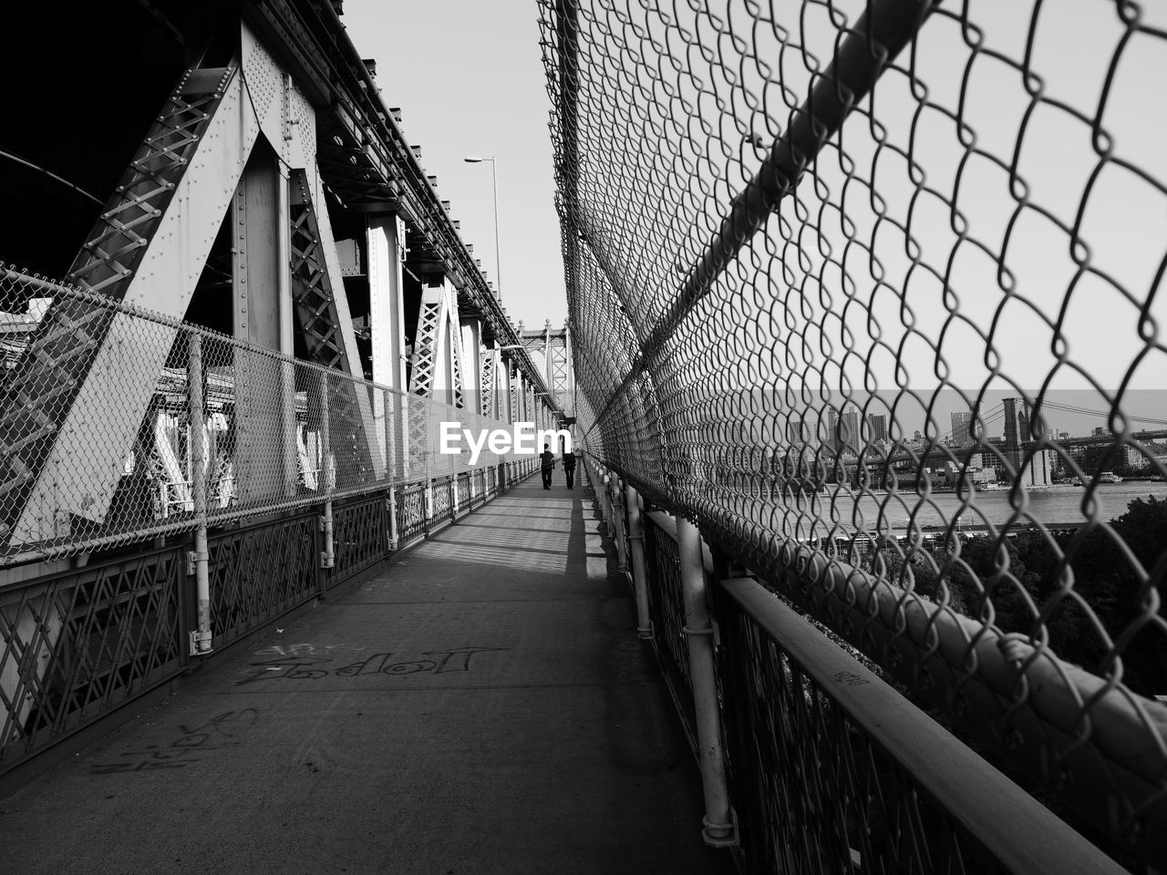 FOOTBRIDGE OVER CHAINLINK FENCE IN CITY