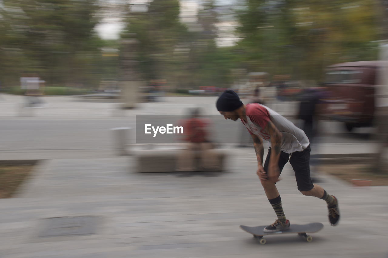 SIDE VIEW OF MAN RIDING ON ROAD