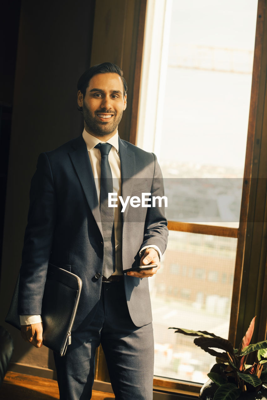 Portrait of smiling lawyer standing in office