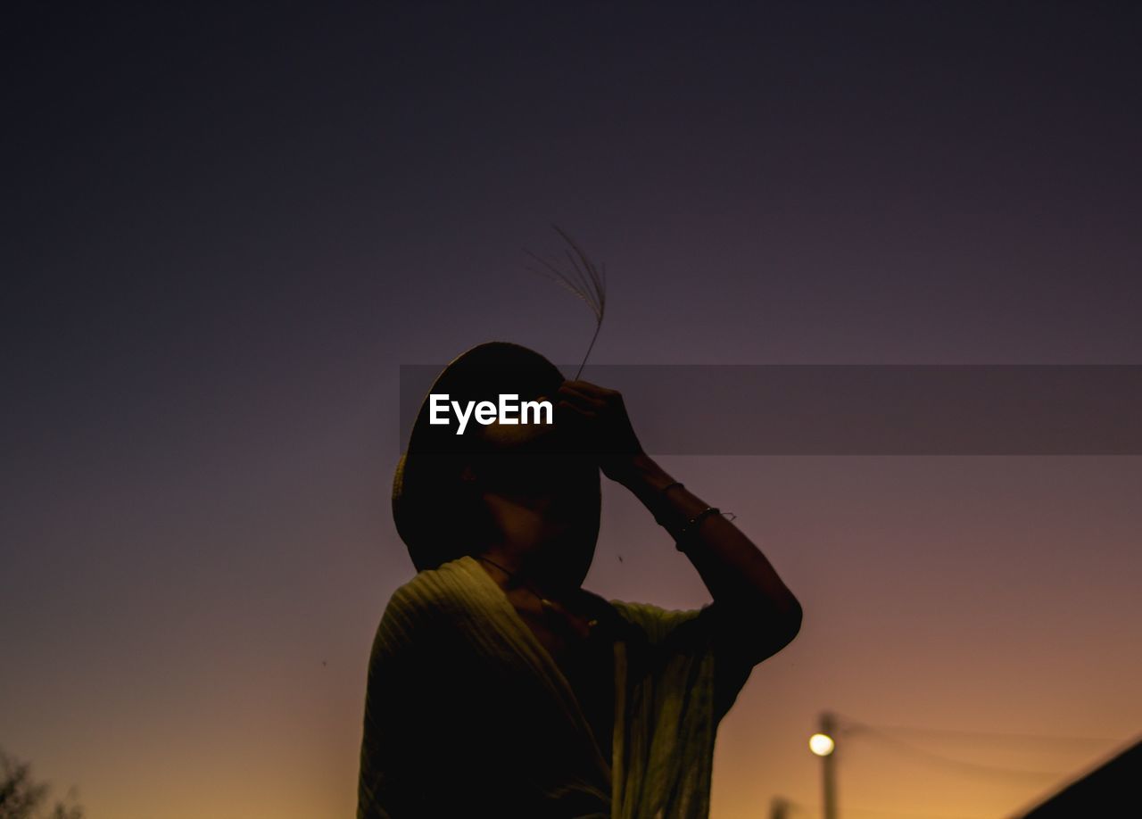 LOW ANGLE VIEW OF SILHOUETTE WOMAN AGAINST CLEAR SKY