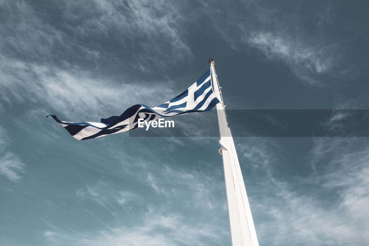 Low angle view of flag against cloudy sky