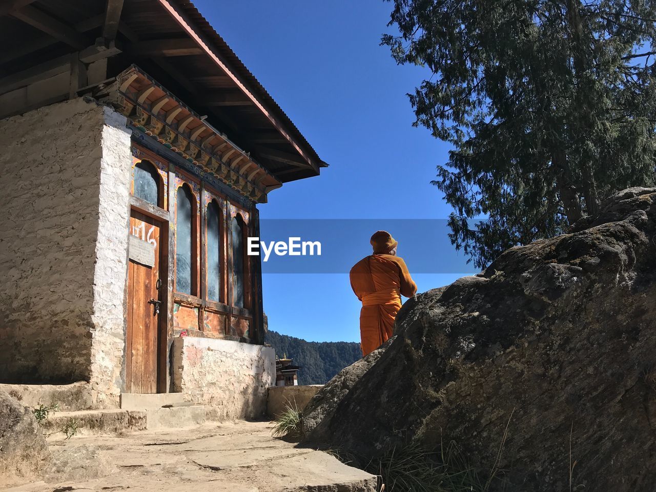 REAR VIEW OF MAN STANDING AGAINST SKY