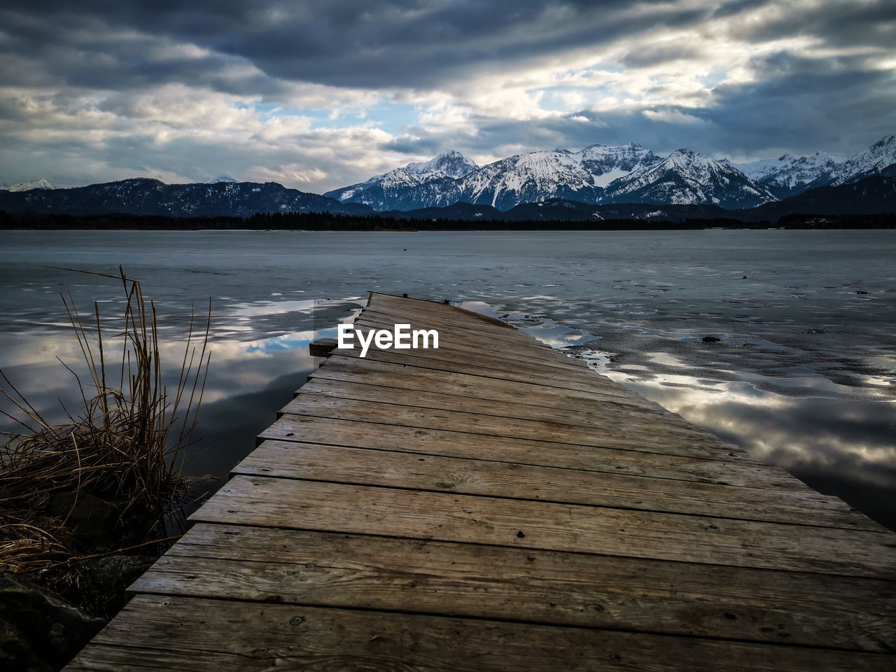 SURFACE LEVEL VIEW OF LAKE AGAINST SNOWCAPPED MOUNTAINS