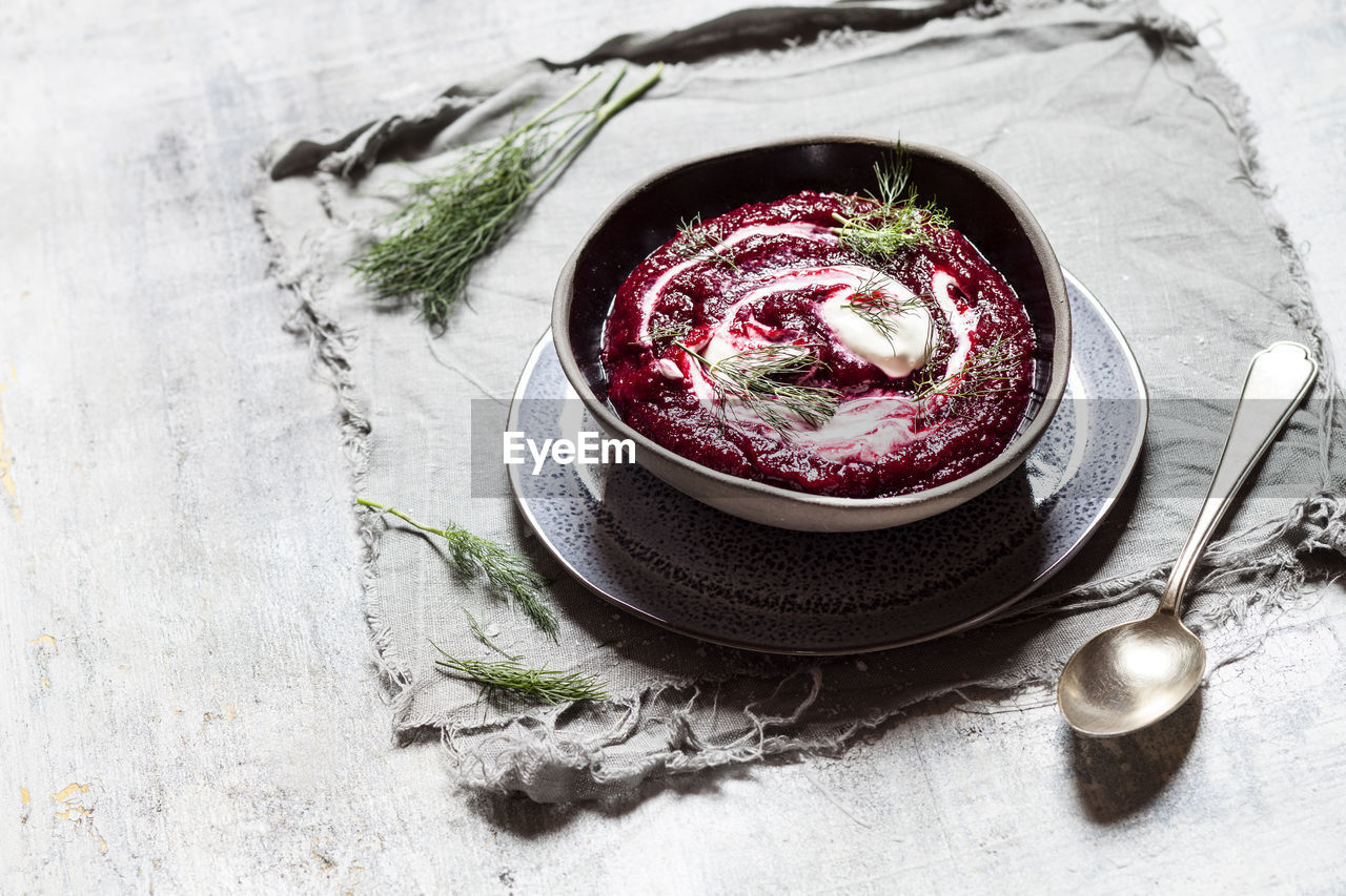 Bowl of traditional borscht with sour cream and dill