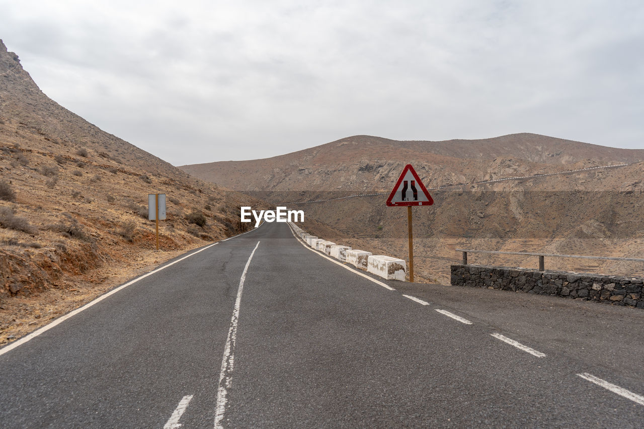 ROAD SIGN AGAINST MOUNTAIN