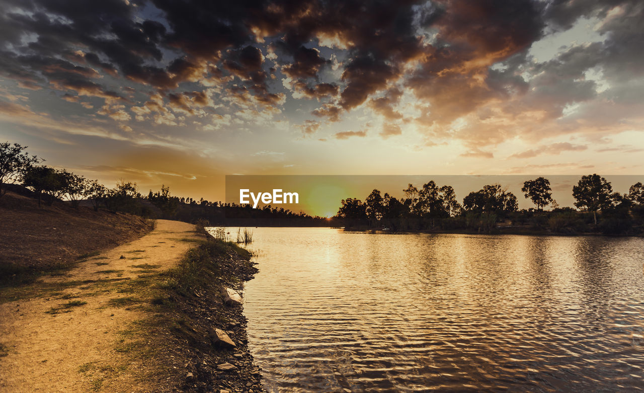 Scenic view of river against sky at sunset