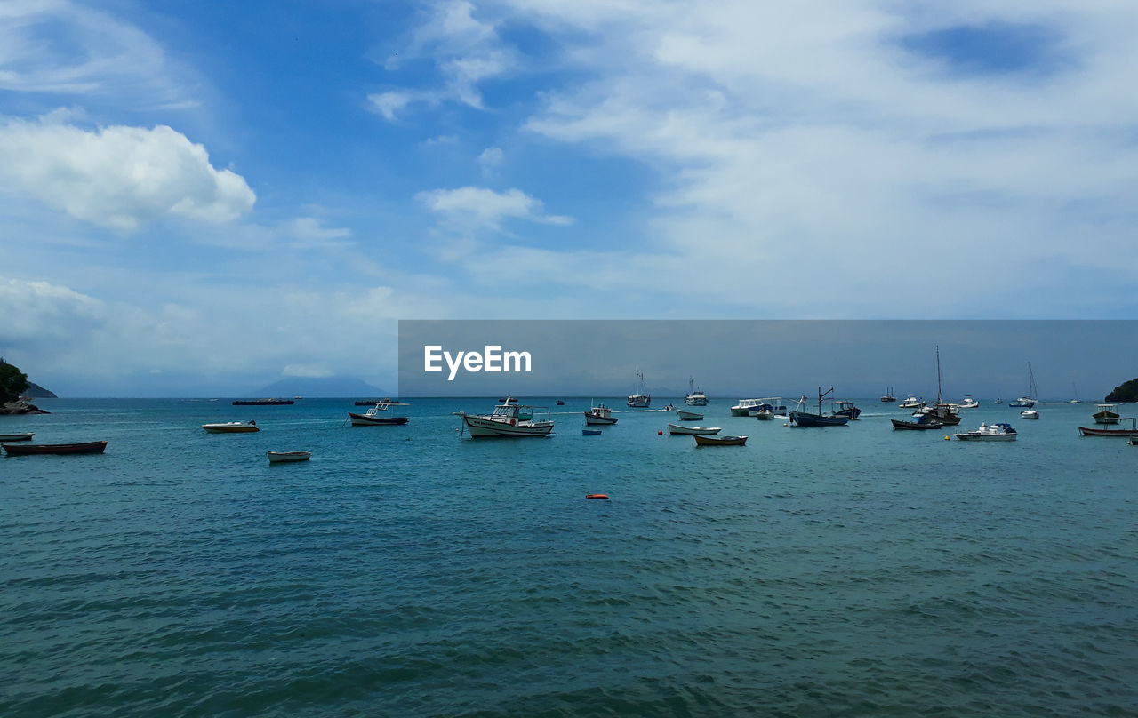 Sailboats in sea against sky