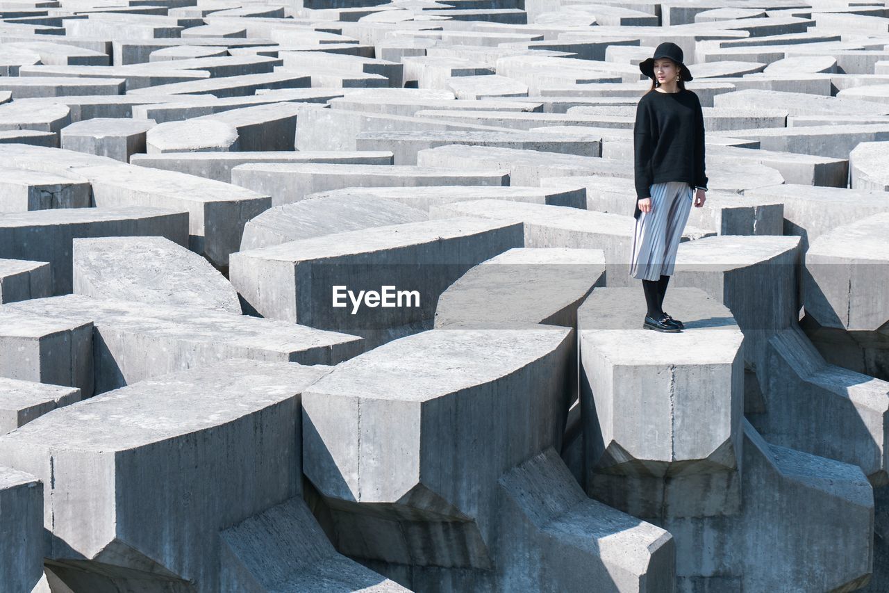 HIGH ANGLE VIEW OF A MAN STANDING ON CONCRETE