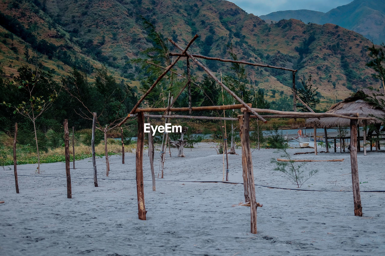 WOODEN POSTS ON BEACH