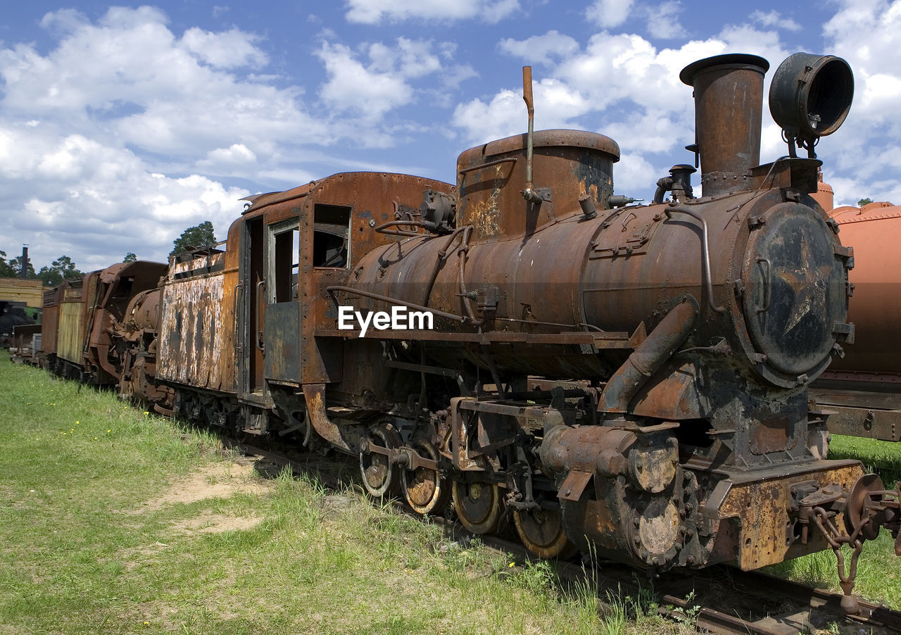 Abandoned train on railroad track against sky