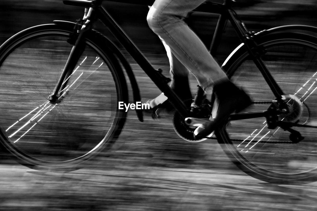 LOW SECTION OF MAN RIDING BICYCLE ON BRIDGE