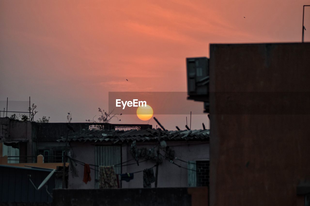 BUILDINGS AGAINST ORANGE SKY