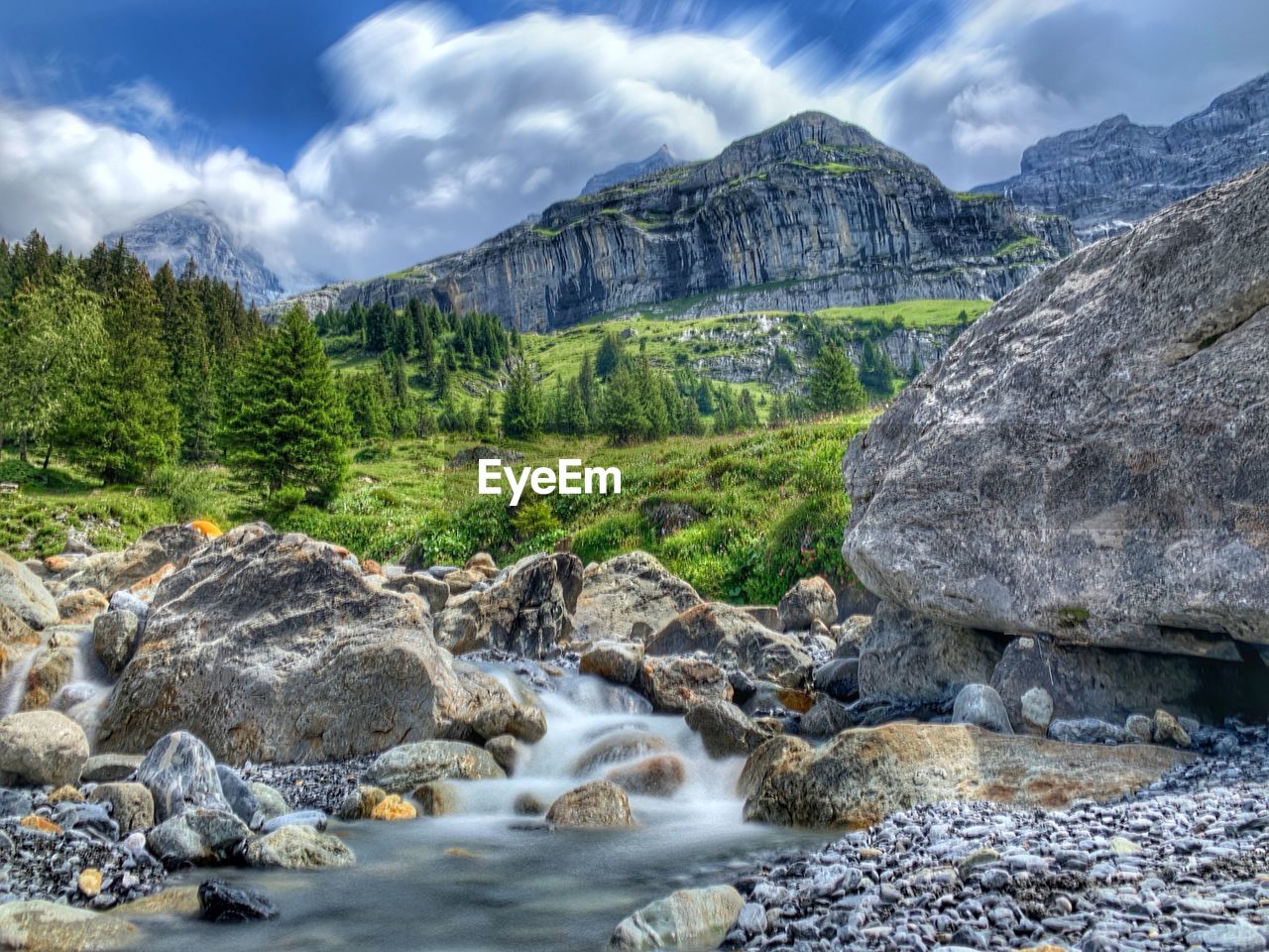 SCENIC VIEW OF STREAM AGAINST ROCKS IN MOUNTAINS