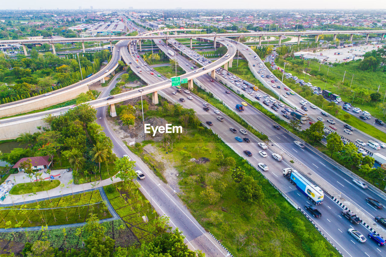 HIGH ANGLE VIEW OF HIGHWAY BY CITYSCAPE