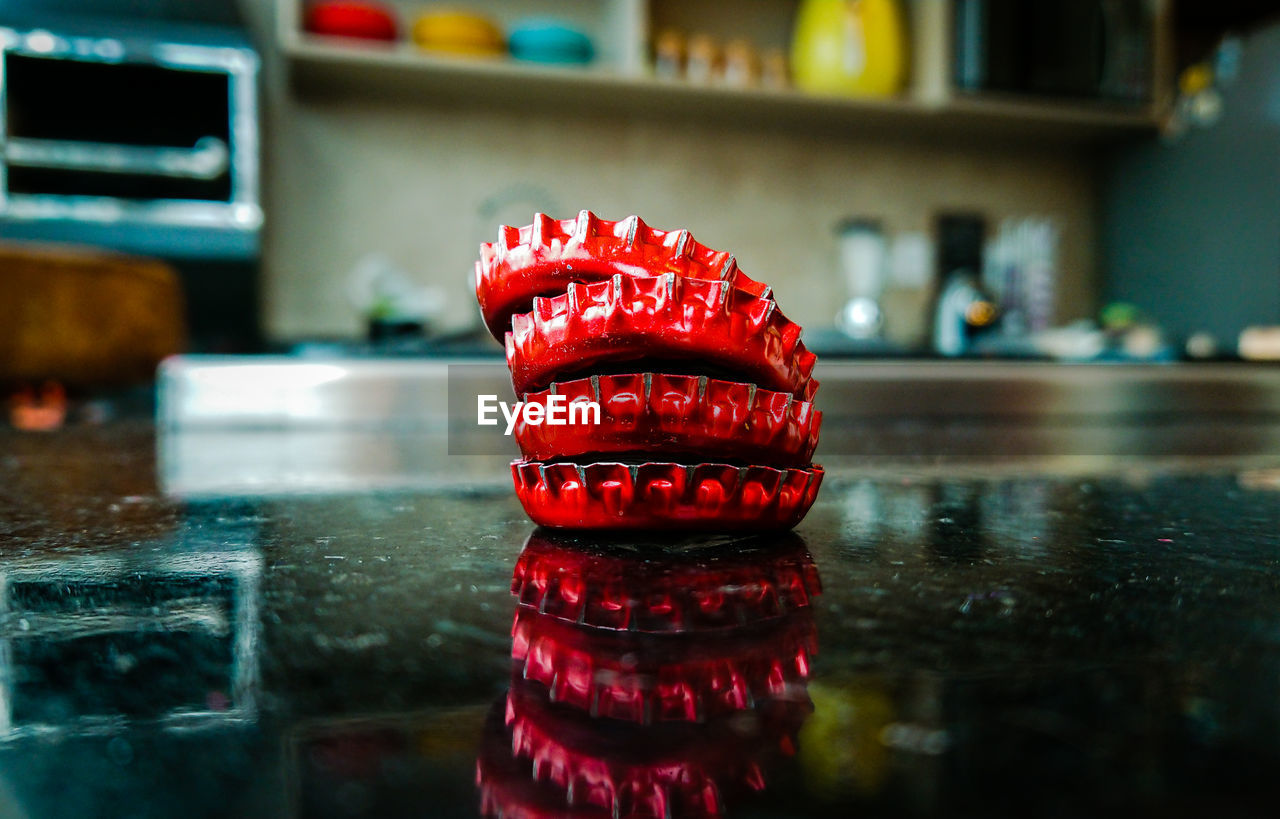 CLOSE-UP OF RED BELL ON TABLE