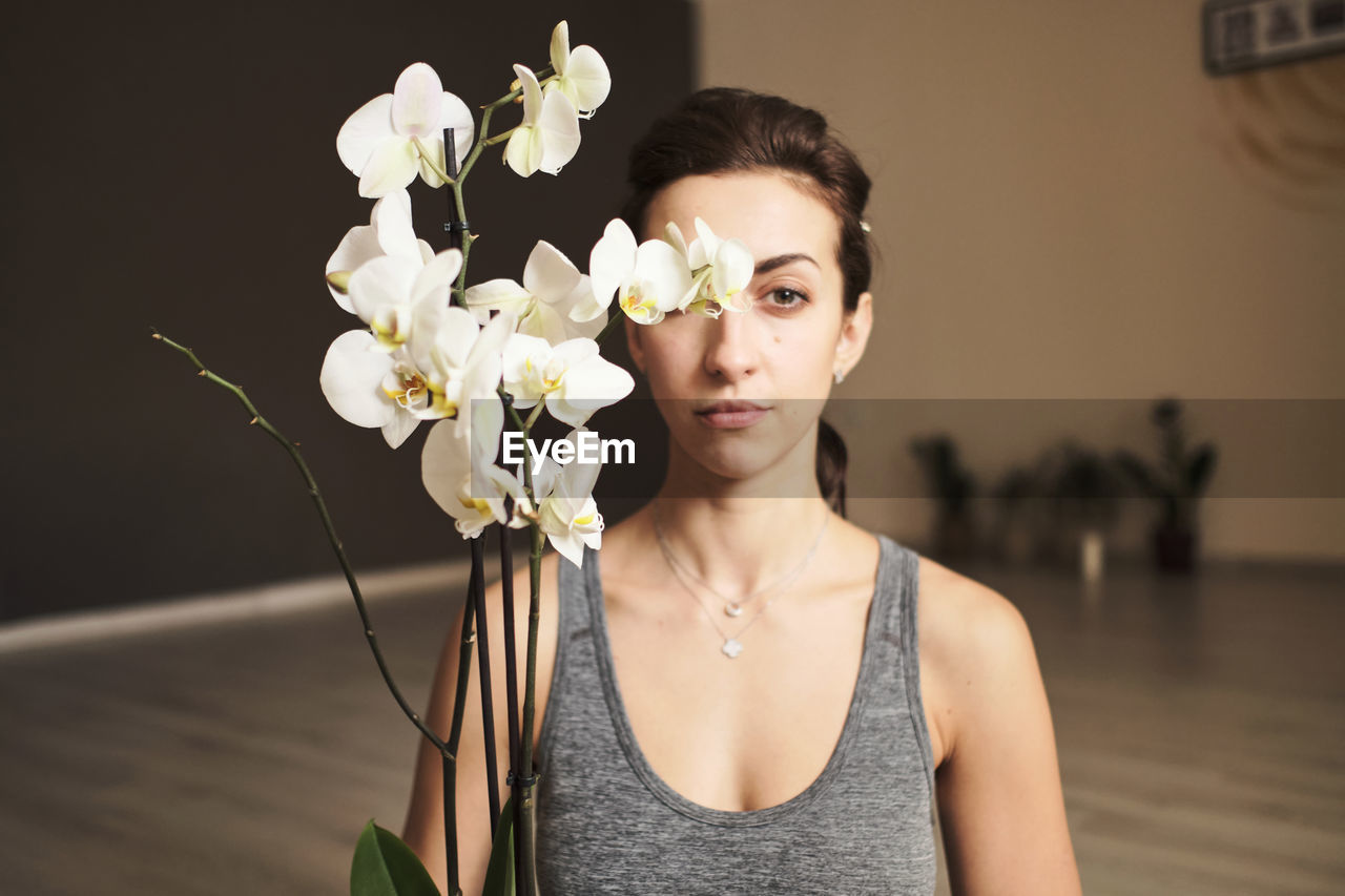 Young woman 30 years old with flowers and home flowerpots