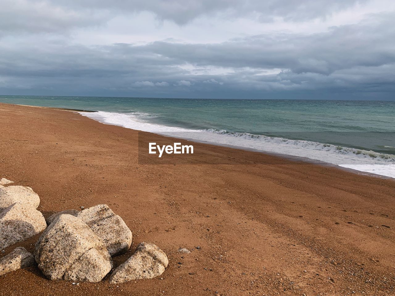 land, sea, beach, water, sky, cloud, sand, body of water, scenics - nature, nature, beauty in nature, environment, shore, water's edge, coast, landscape, travel destinations, ocean, coastline, travel, wave, horizon over water, motion, tranquility, wind wave, horizon, holiday, tourism, trip, no people, vacation, seascape, tranquil scene, dramatic sky, cloudscape, outdoors, overcast, day, rock, storm, sports, summer, idyllic, non-urban scene, island, water sports, tropical climate, urban skyline, coastal feature, backgrounds, storm cloud