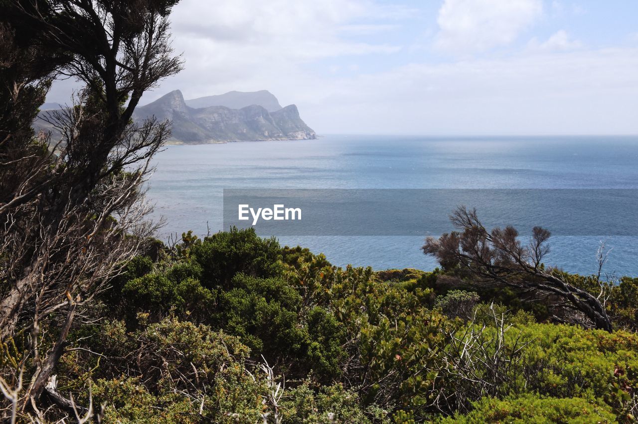 Scenic view of sea and mountains against sky