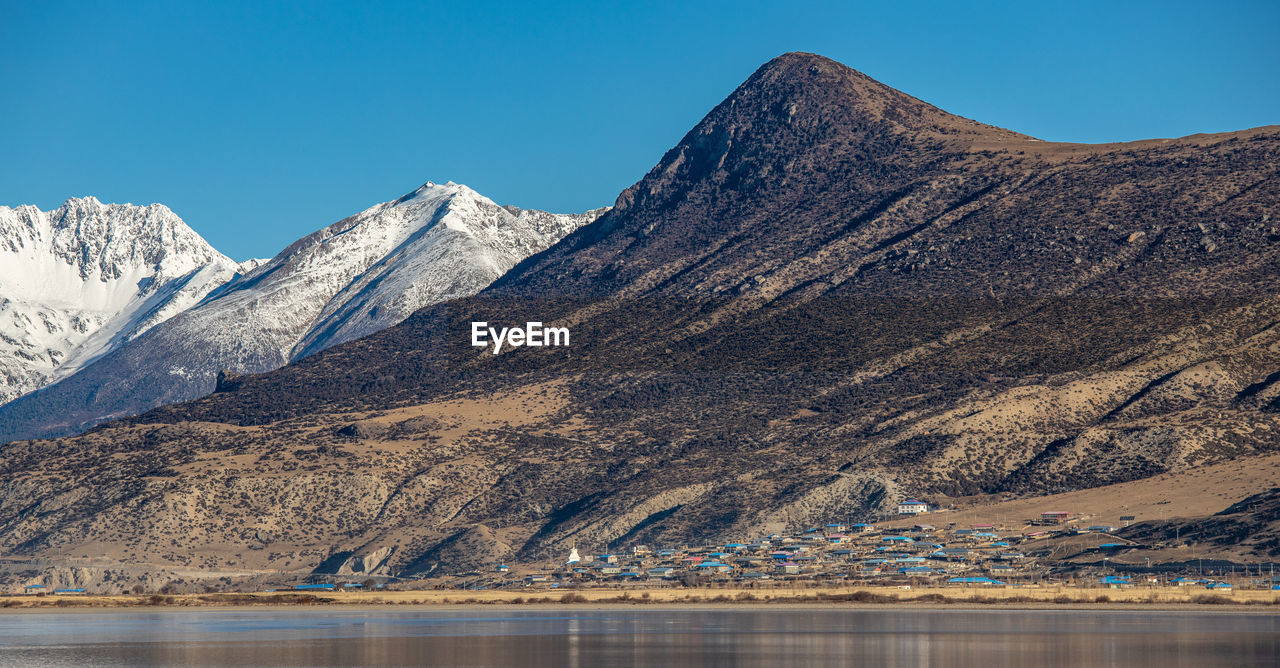 Scenic view of snowcapped mountains against clear sky