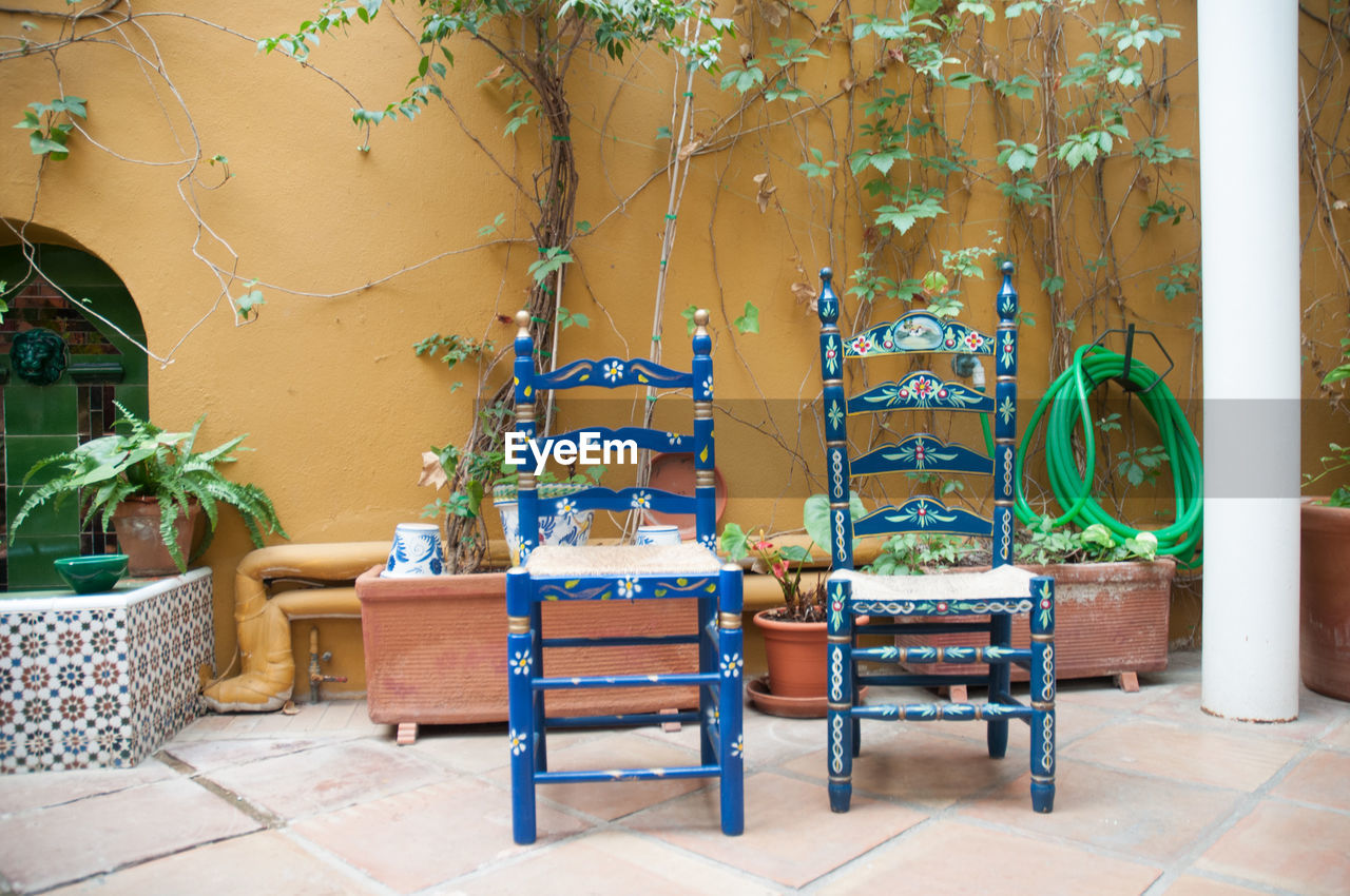 Empty wooden chairs in yard