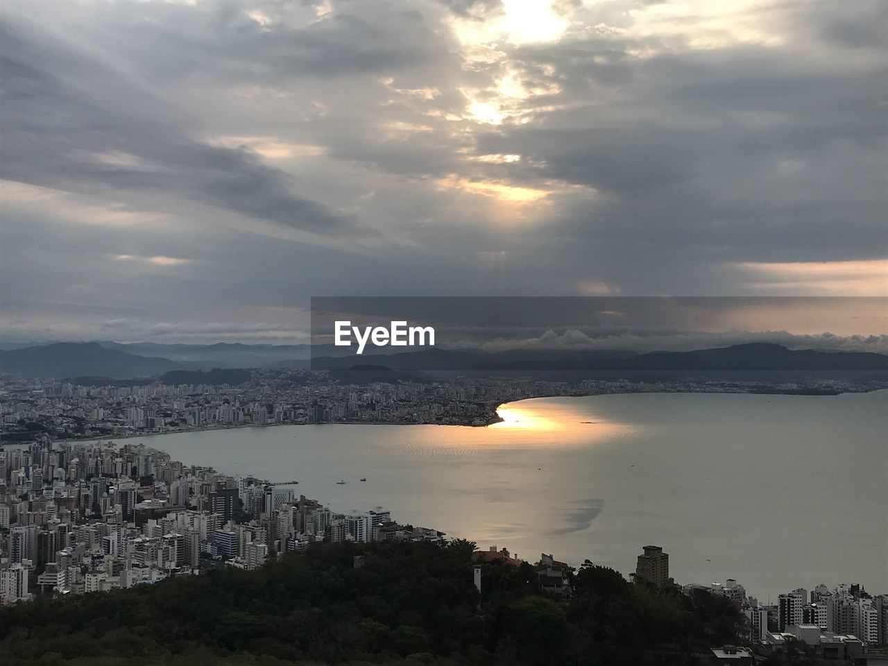 HIGH ANGLE VIEW OF SEA AND BUILDINGS AGAINST SKY