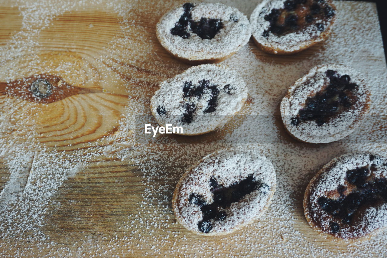 Directly above shot of chocolate cupcakes with powdered sugar on cutting board