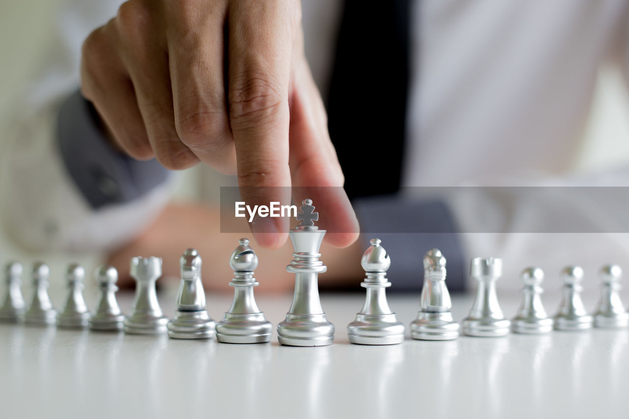 Cropped image of person holding chess piece