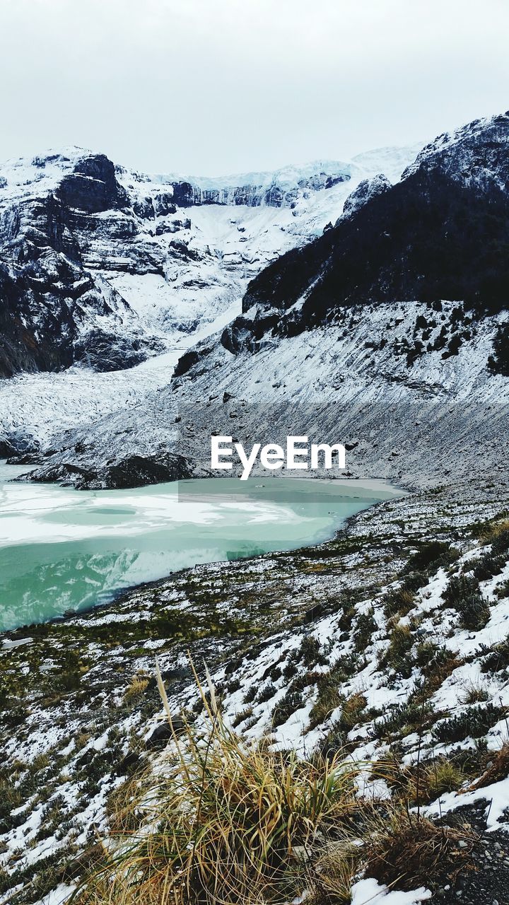 SCENIC VIEW OF FROZEN LAKE AGAINST MOUNTAIN