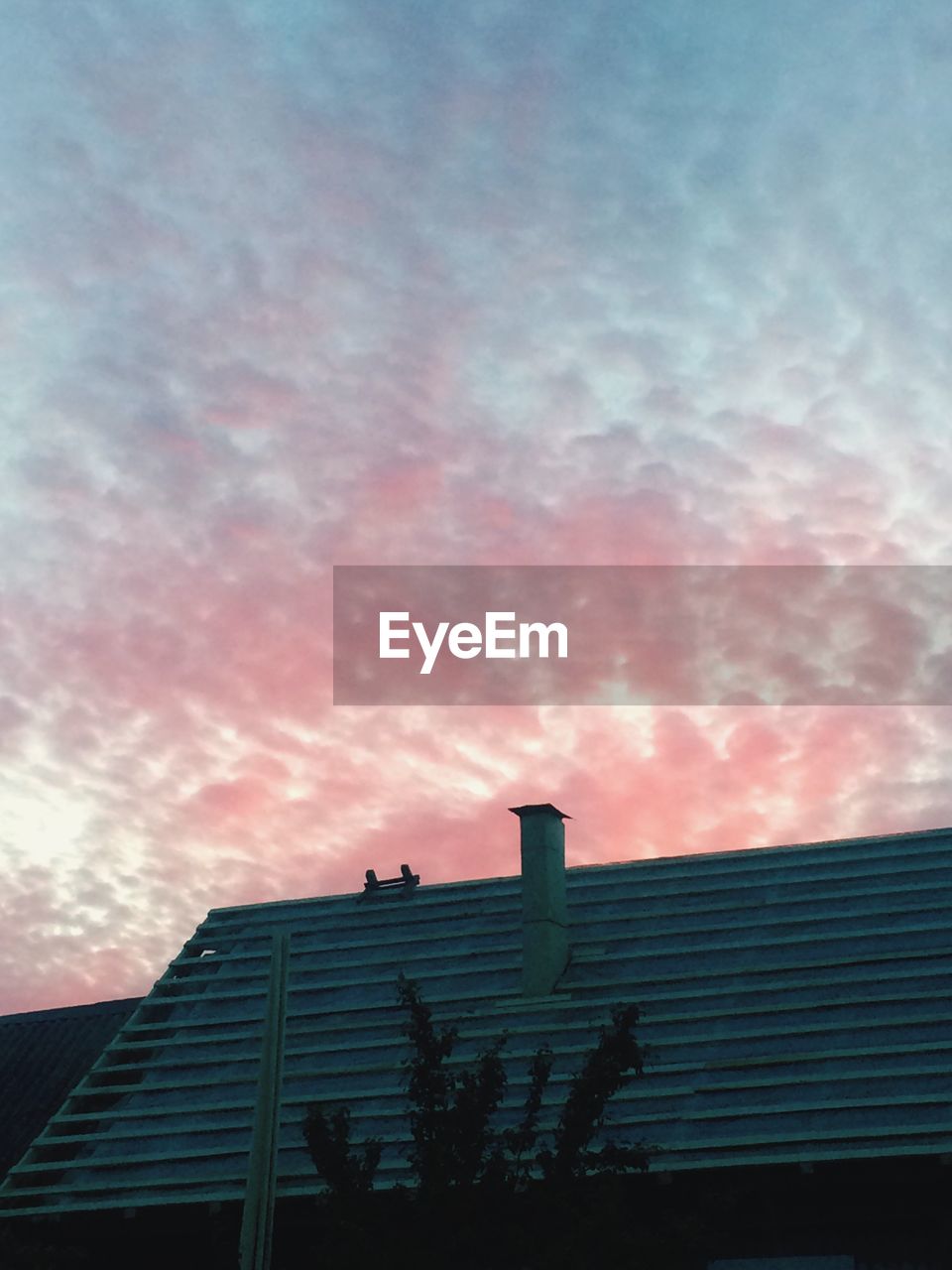 LOW ANGLE VIEW OF HOUSES AGAINST CLOUDY SKY