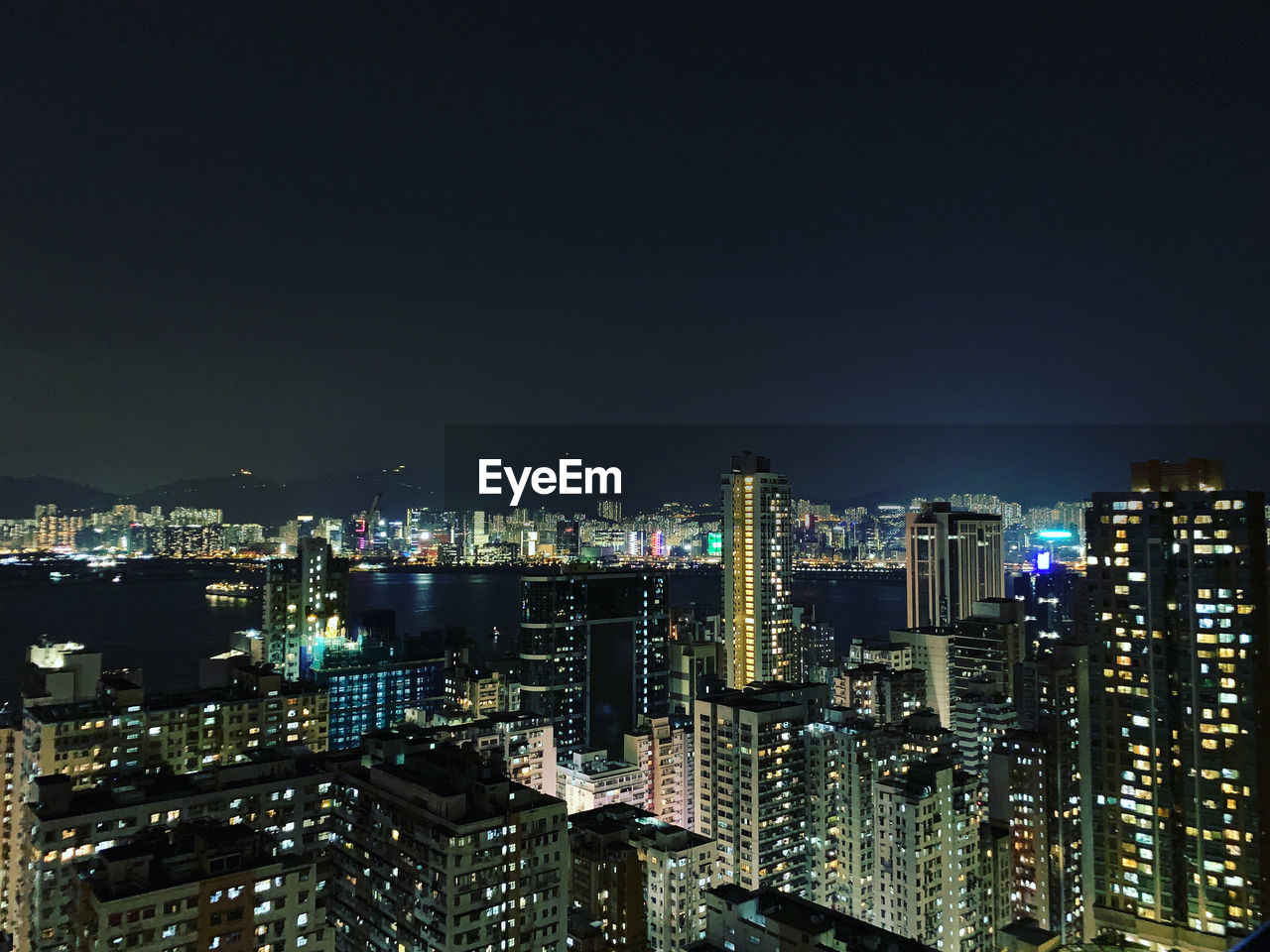 Illuminated buildings in city against sky at night in hong kong 