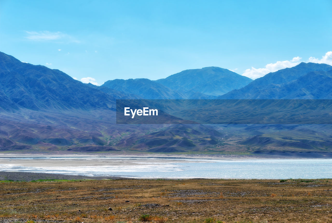 Scenic view of sea and mountains against sky