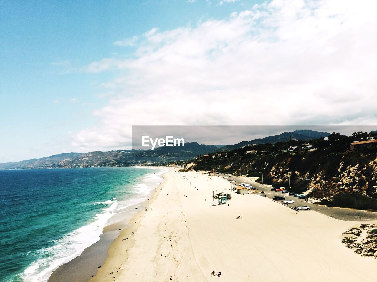 Scenic view of beach against cloudy sky