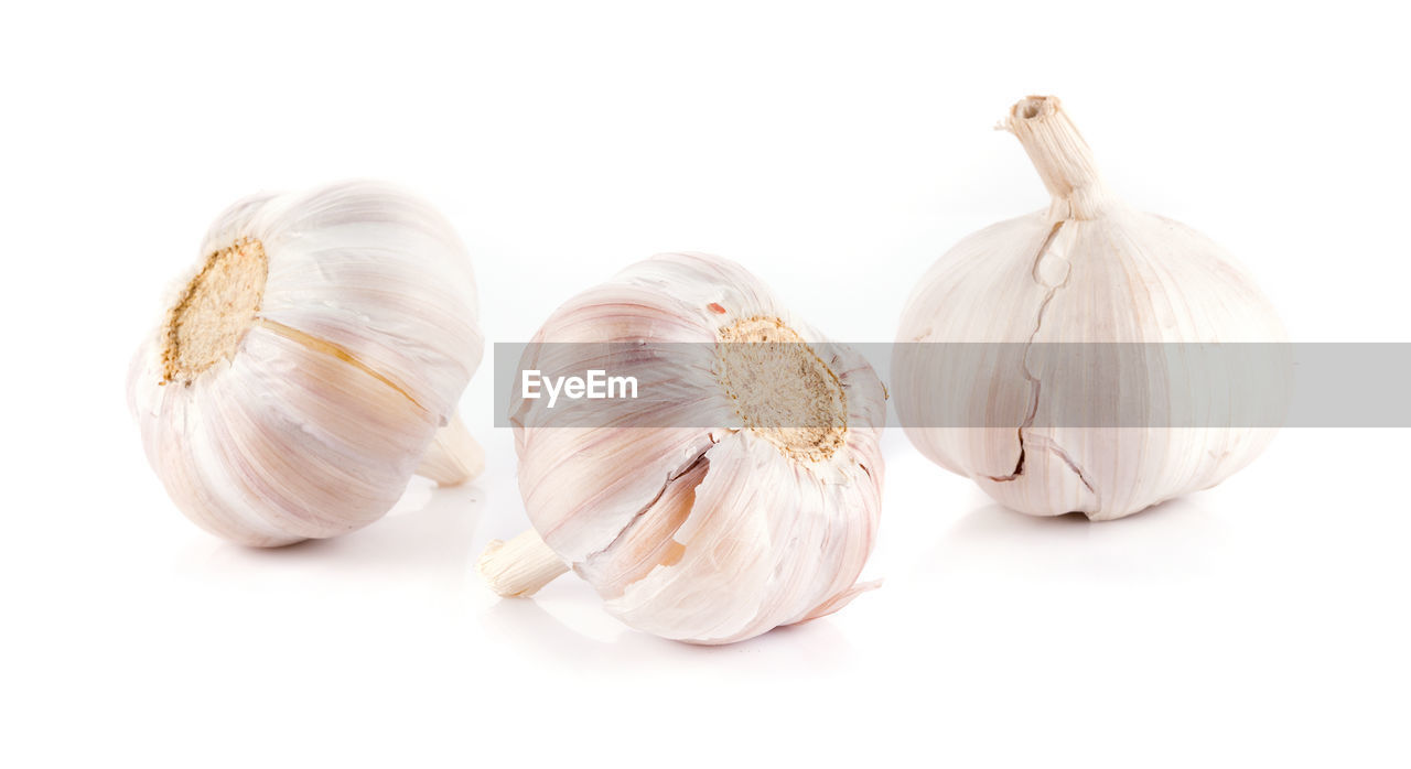 Close-up of garlic bulbs against white background