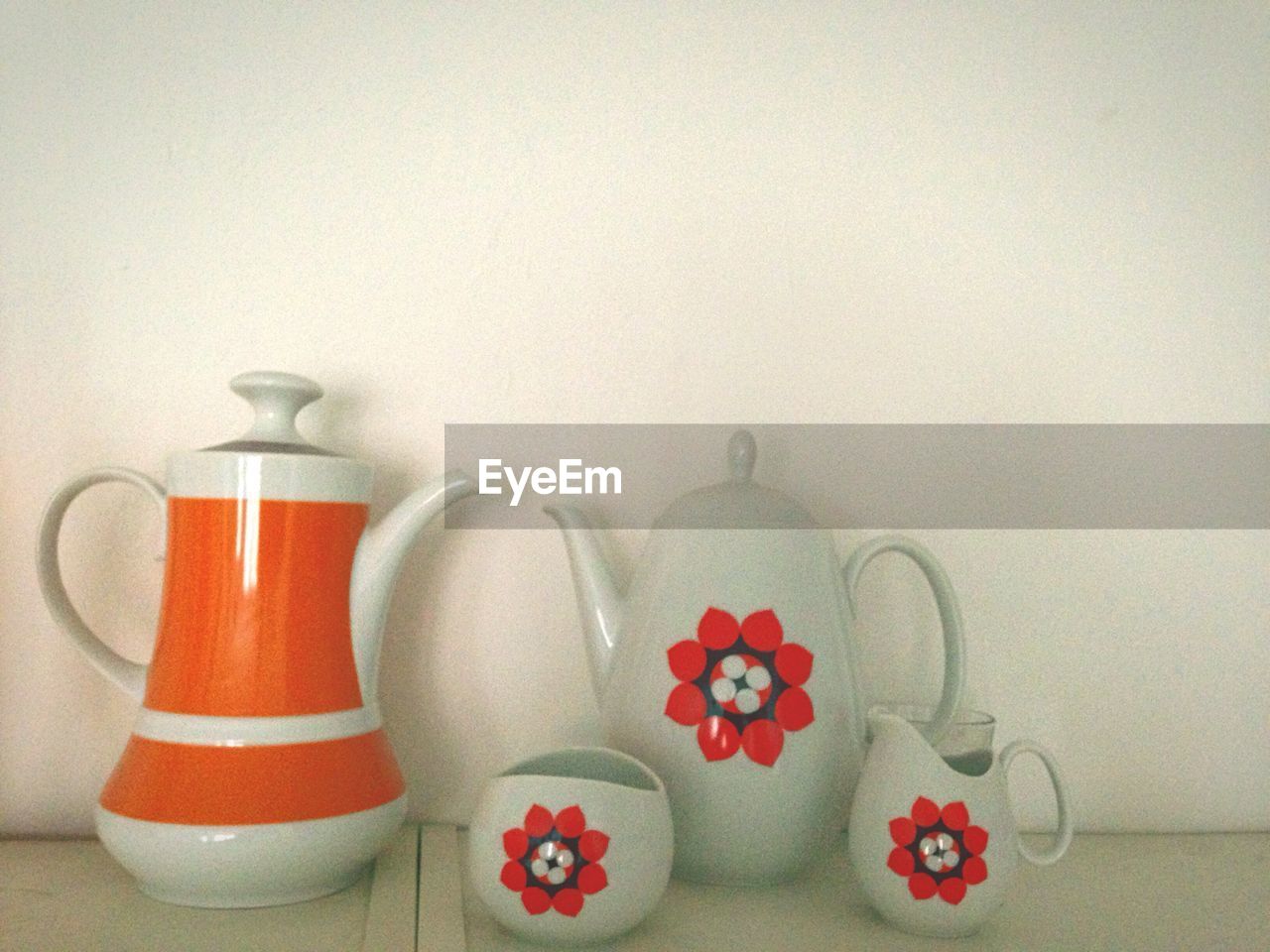 Various coffee pots on table against wall