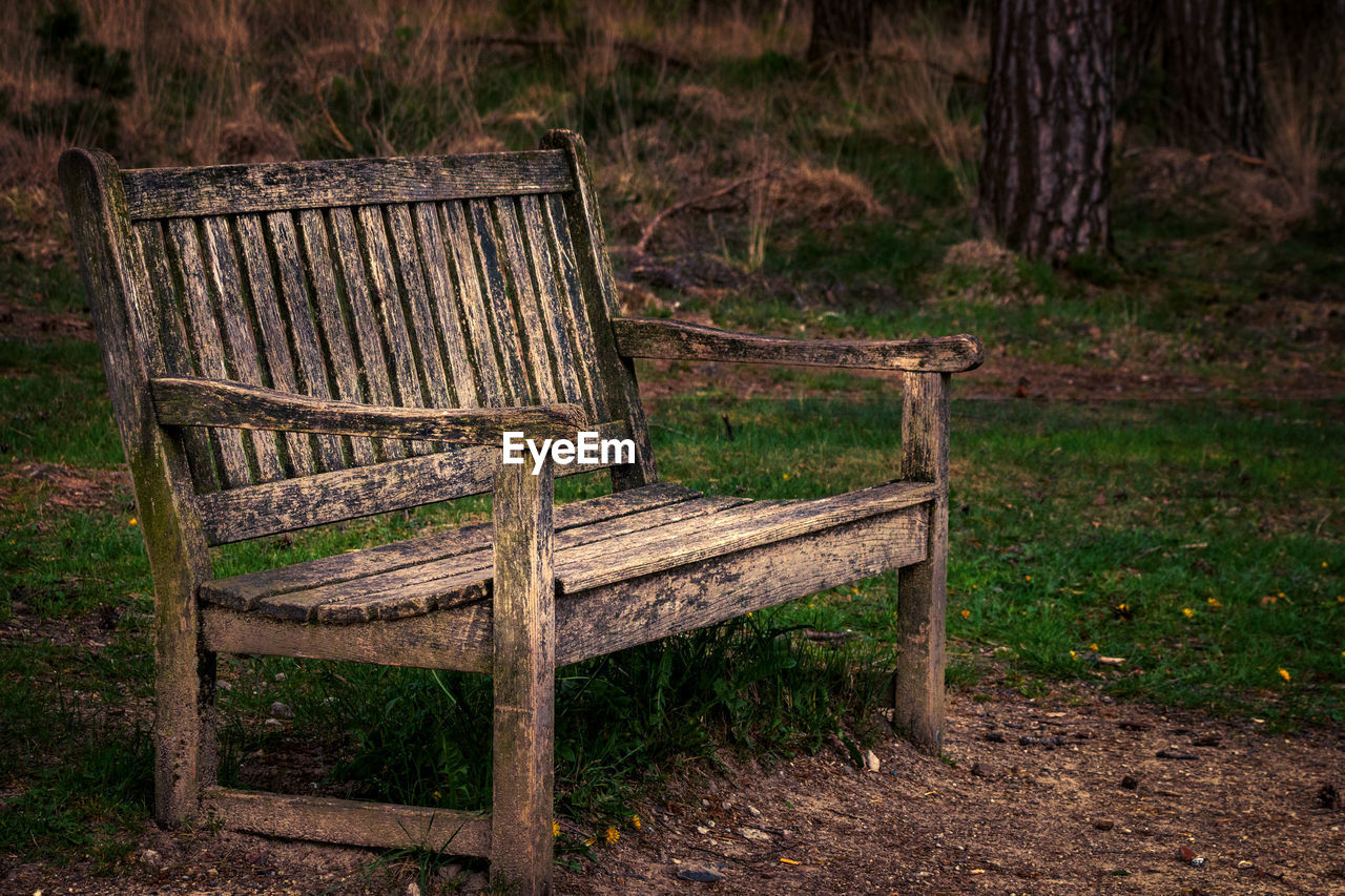 Empty wooden bench on field 