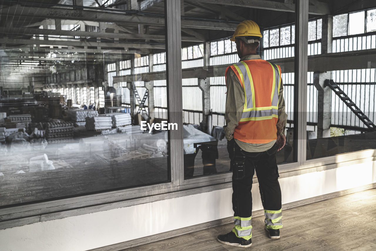 Rear view of engineer standing in factory